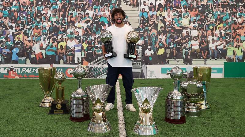 Gustavo Scarpa é homenageado pelo Palmeiras em sessão de fotos com os troféus conquistados pela sua passagem no clube na Academia de Futebol.
